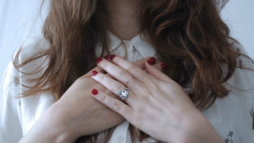 Woman With Hands Over Chest